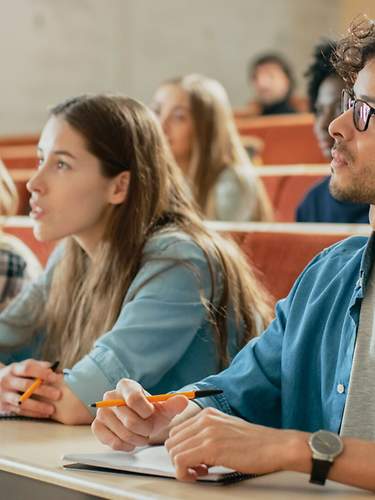 Versicherungen für Studenten. Eine Gruppe von Studenten spaziert über einen Weg.