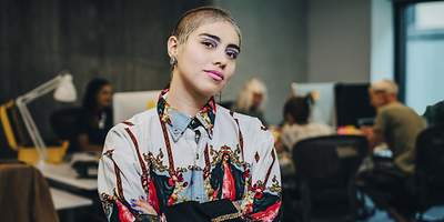 Ein junger Single-Mann tanzt auf seinem Sofa und spielt Luftgitarre.