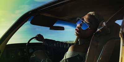 Frau mit Sonnenbrille sitzt im Auto