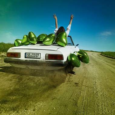 Weißes Cabriolet mit grünen Luftballons