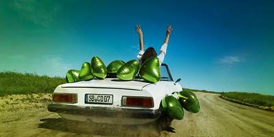 Weißes Cabriolet mit grünen Luftballons