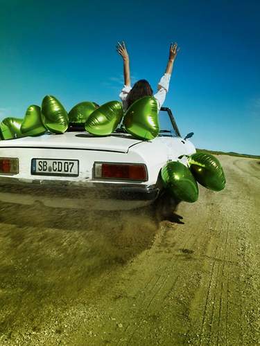 Weißes Cabriolet mit grünen Luftballons