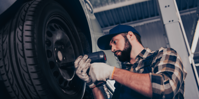 Mann beim Reifenwechsel