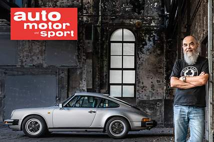 Ein älterer Mann steht vor einem Porsche.