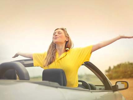 Frau mit gelbem T-Shirt im Cabriolet