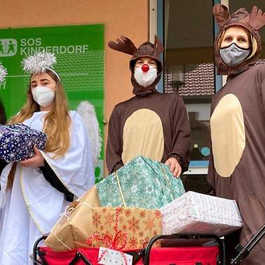 Vier verkleidete Menschen mit Geschenken