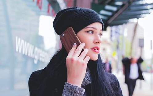 Eine Frau mit schwarzen Haaren telefoniert mit einem Smartphone
