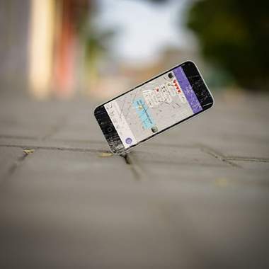 Ein Handy fällt auf den Boden und das Display zerbricht