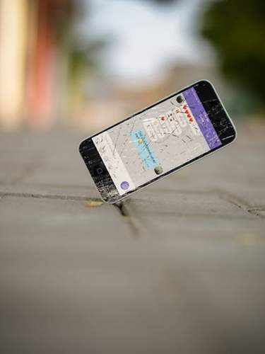 Ein Handy fällt auf den Boden und das Display zerbricht