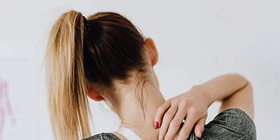 Frau mit Nackenschmerzen