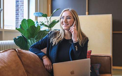 Frau arbeitet im Homeoffic bzw. auf dem Sofa