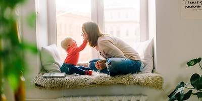 Mutter mit Kind auf einer Fenstersitzbank