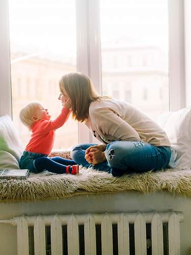 Mutter mit Kind auf einer Fenstersitzbank