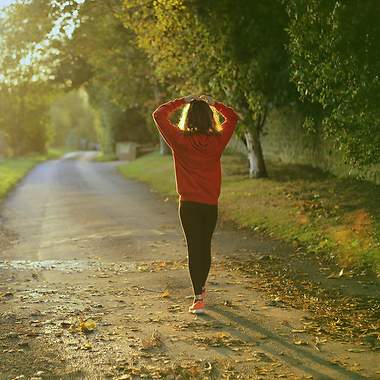Eine Frau in Sportkleidung geht eine Straße entlang