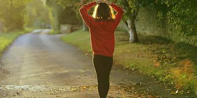 Eine Frau in Sportkleidung geht eine Straße entlang