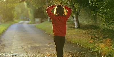 Eine Frau in Sportkleidung geht eine Straße entlang