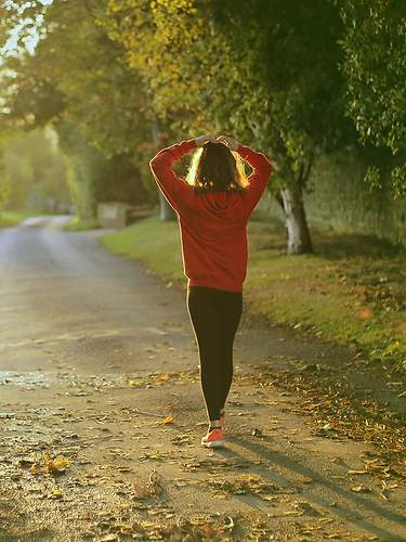 Eine Frau in Sportkleidung geht eine Straße entlang