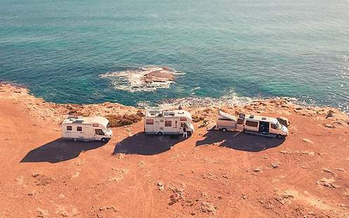 Drei Wohnmobile an der Küste