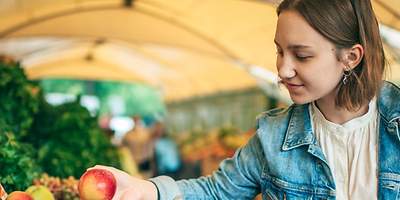 Frau kauft frisches Gemüse
