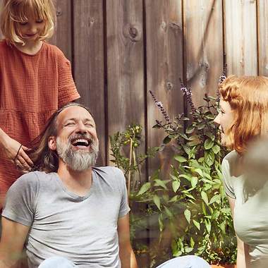 Lachender Mann mit Frau und Kind