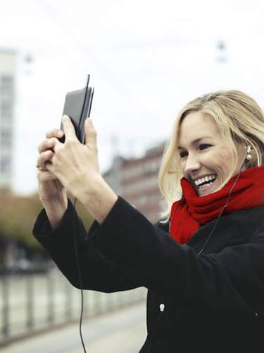 Frau mit rotem Schal und Handy in der Hand