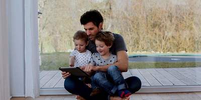 Mann mit zwei Kindern auf dem Schoß