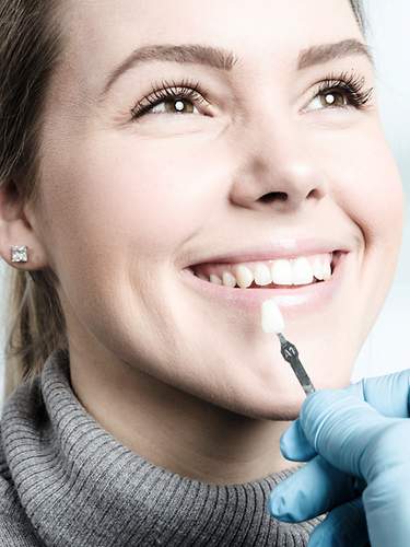 Das Bild zeigt eine Frau, die eine Zahnbehandlung beim Zahnarzt bekommt. 